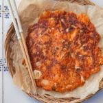 Crispy kimchi pancake (kimchi jeon) on a serving platter.