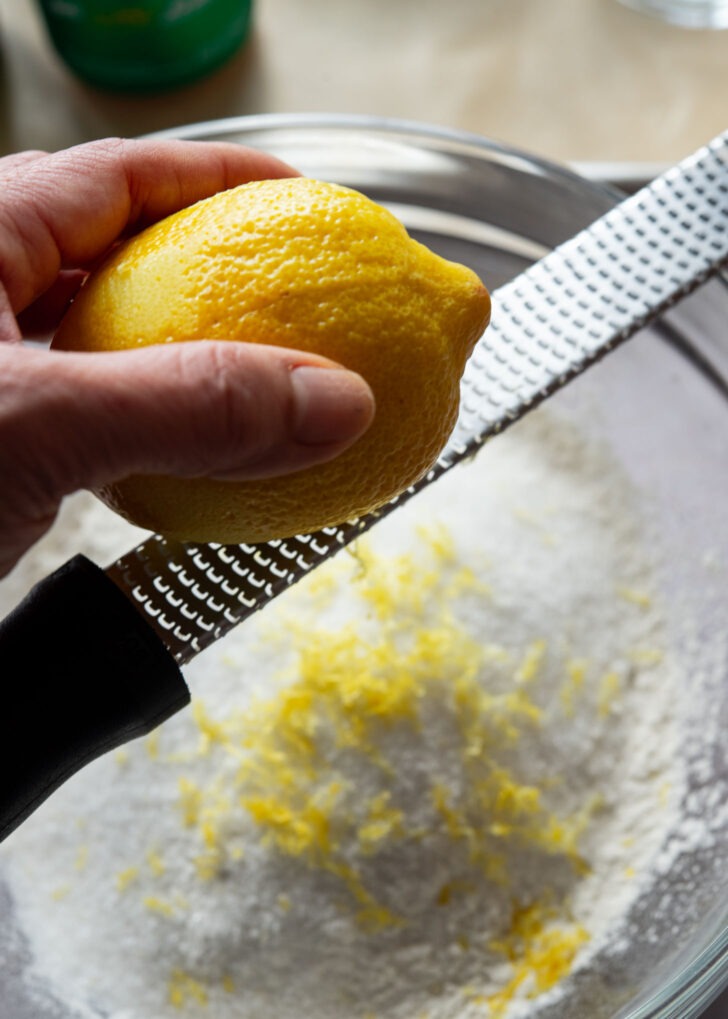 Lemon zest added to dry ingredients in a bowl.