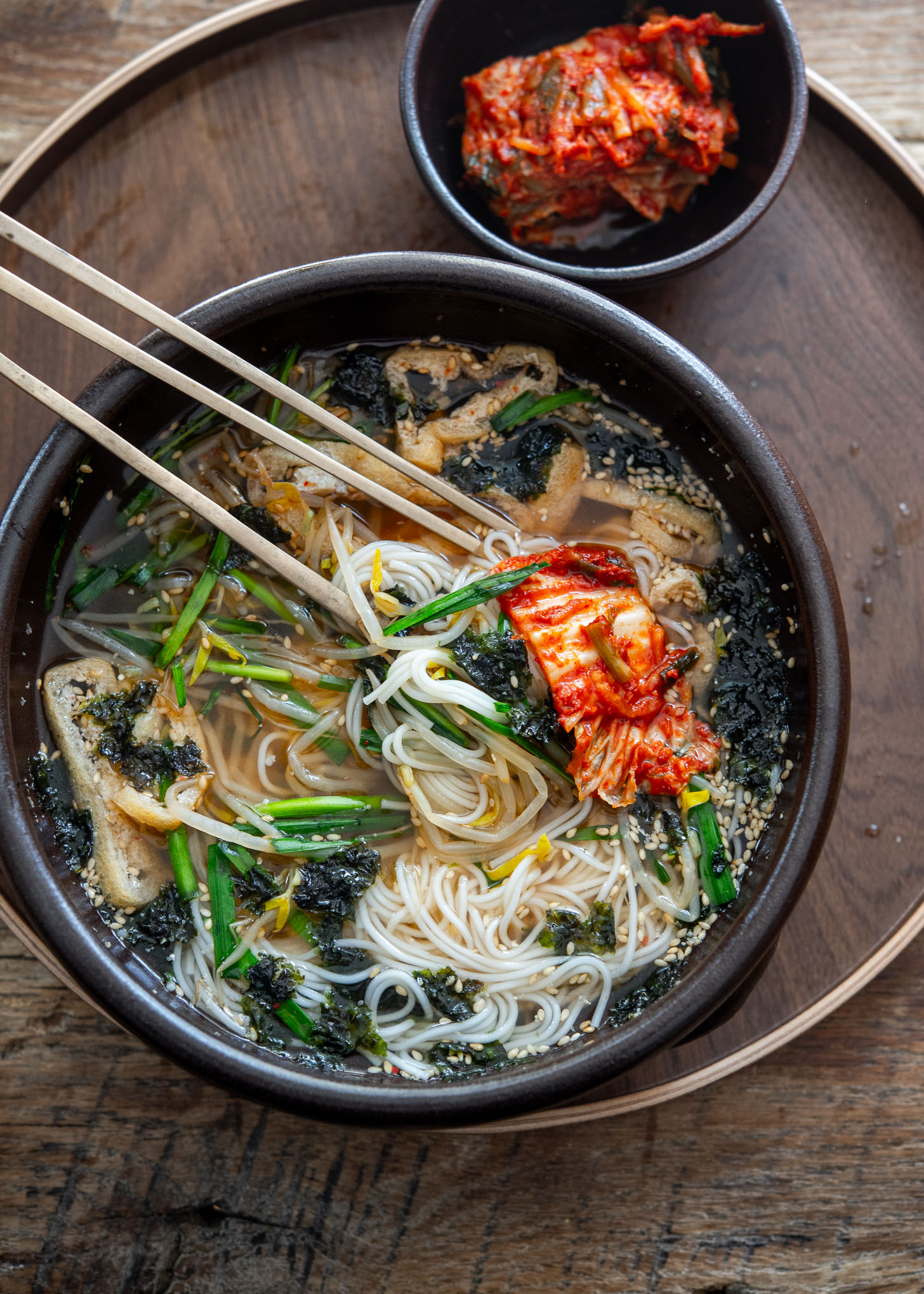Serving janchi guksu with a side of kimchi for a traditional Korean meal.