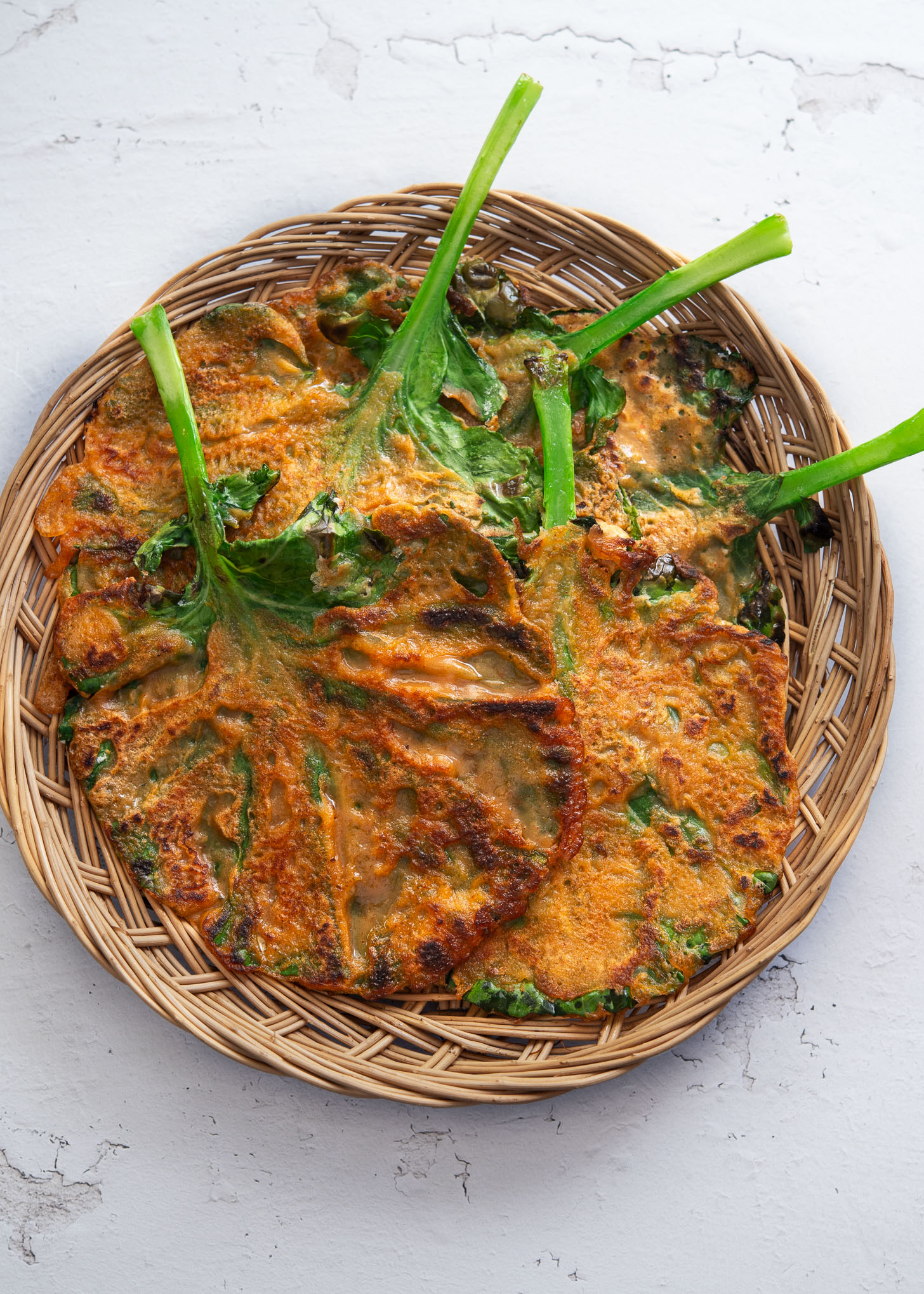Crispy kale gochujang pancakes served in a woven basket tray