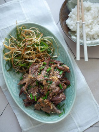 Korean doenjang pork (maekjeok) served with green onion salad and rice.
