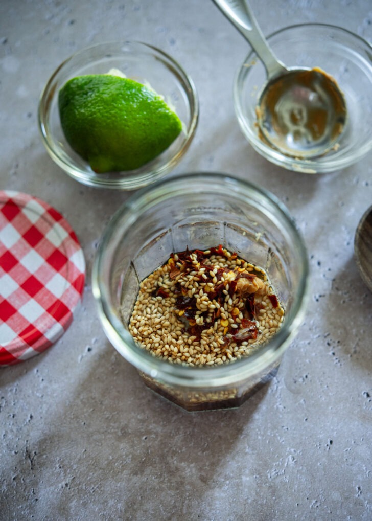 Peanut butter, soy sauce, lime juice and seasonings mixed in a jar for salad dressing