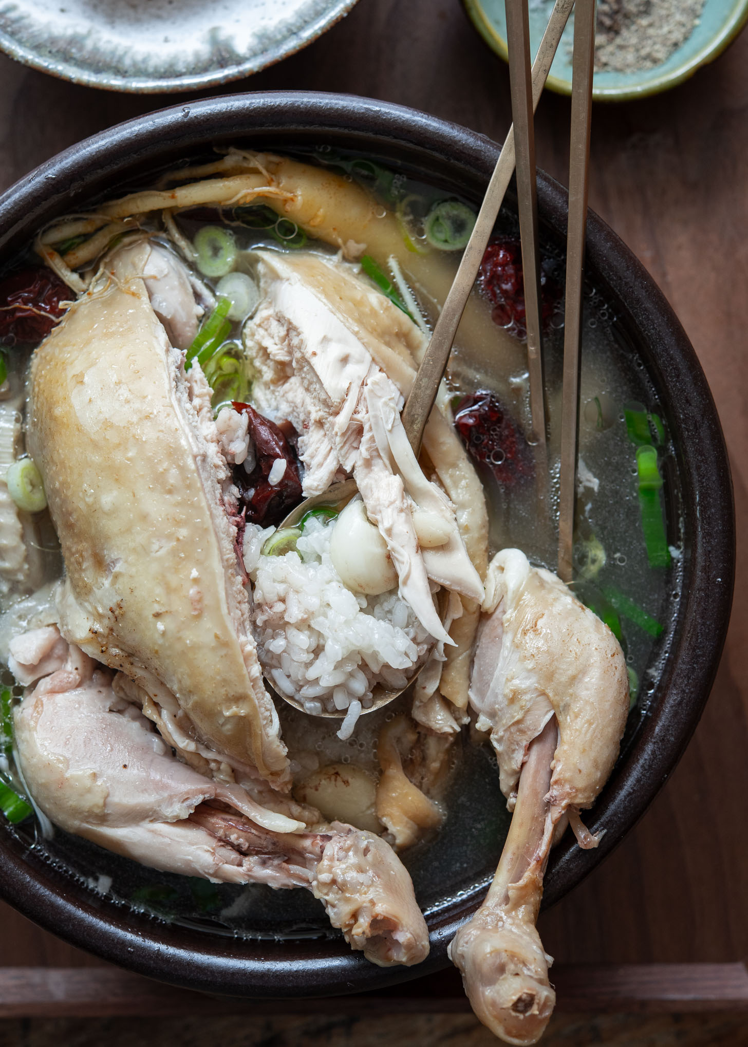 Scooping rice from the chicken cavity in samgyetang soup
