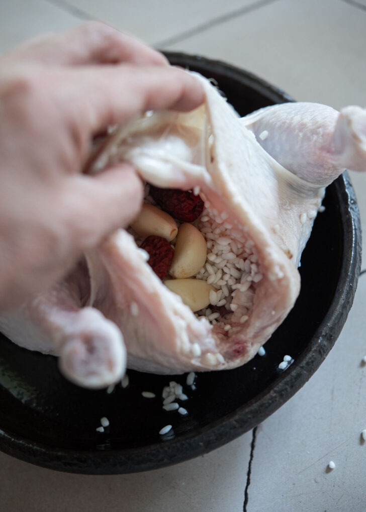 Stuffing chicken cavity with glutinous rice, jujube, and garlic for samgyetang
