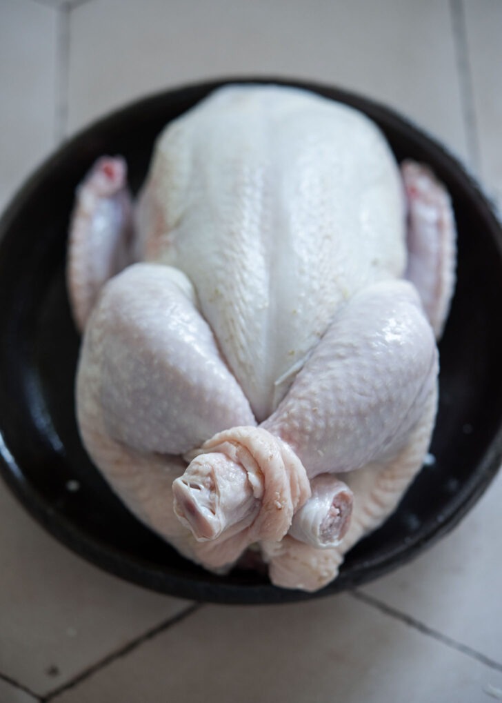 Chicken legs crossed and tucked through slits to close cavity