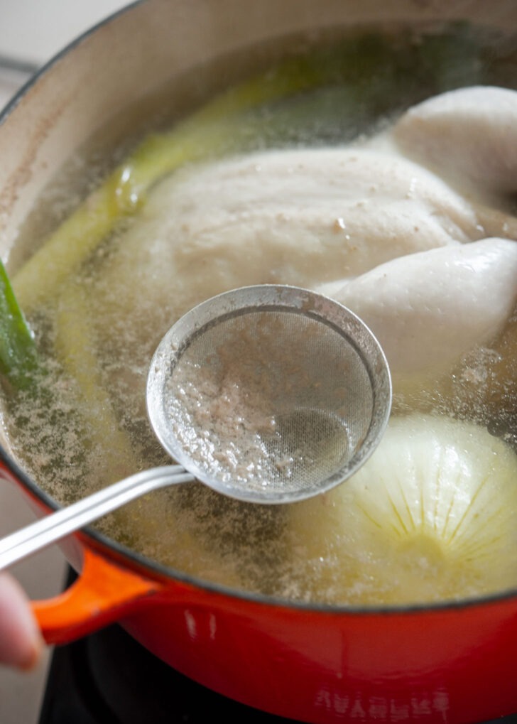 Skimming foam and impurities from simmering chicken broth

