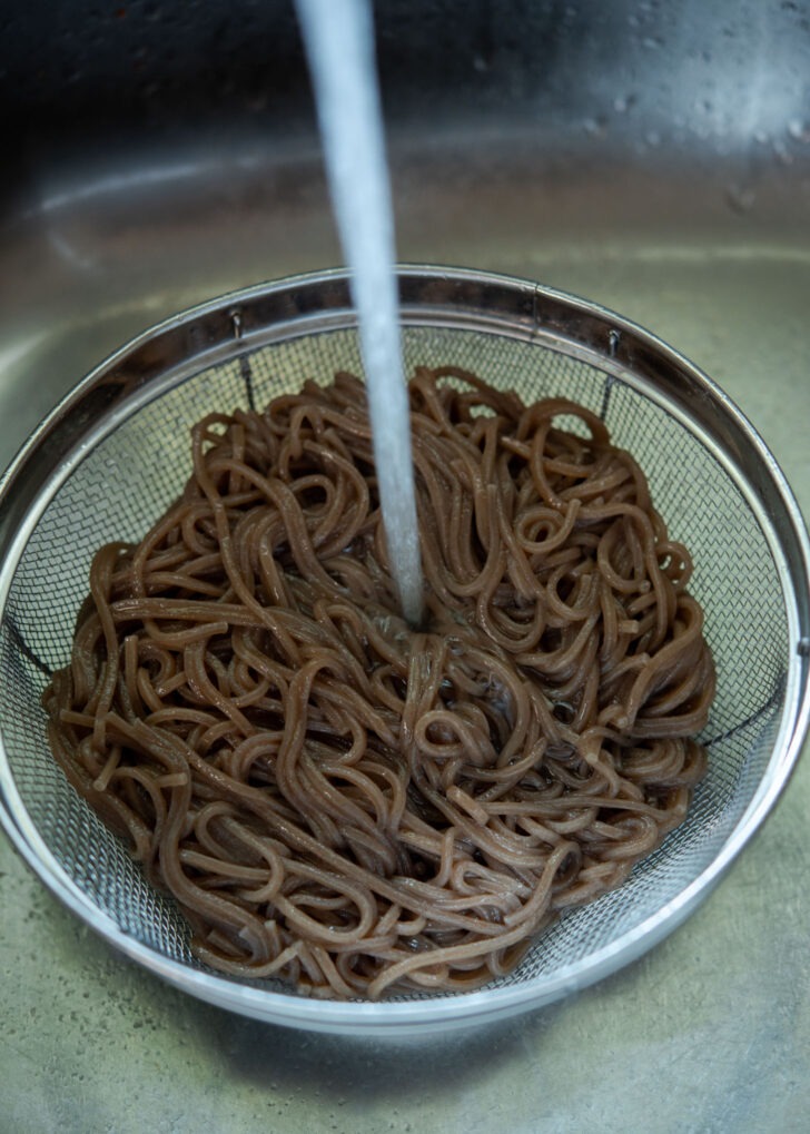 Rinsing cooked buckwheat noodles under the cold running water