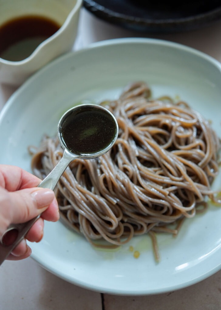 Adding the noodle dressing over the cold buckwheat noodles