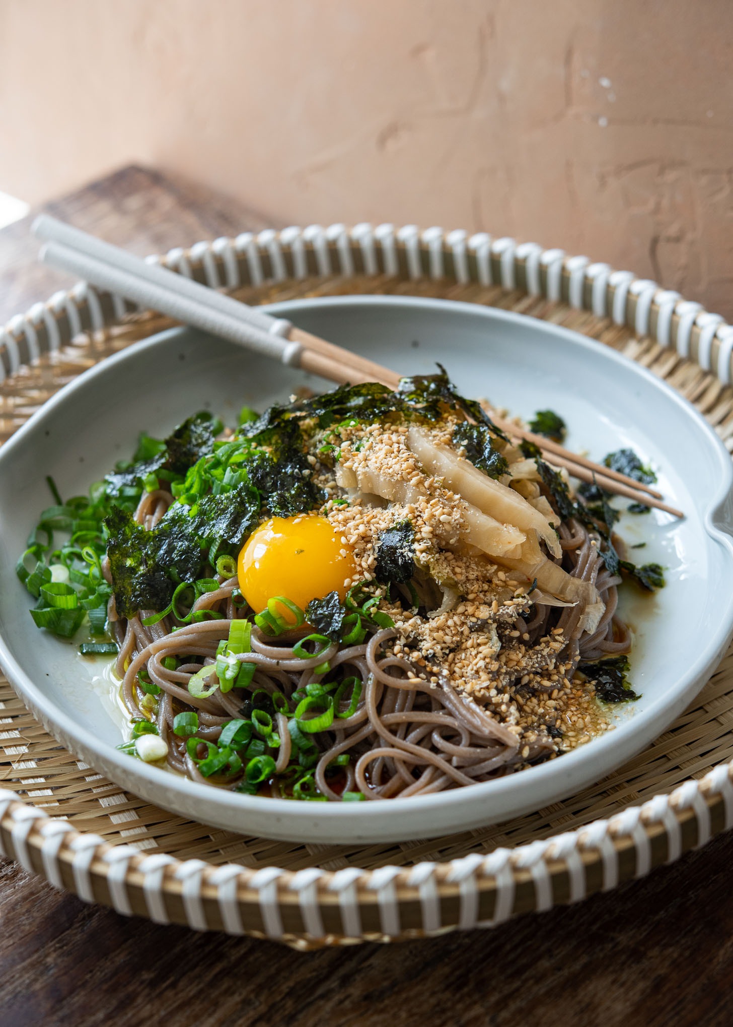 Makguksu topped with kimchi, green onion, egg, yolk, crumbled seaweed and sesame seeds