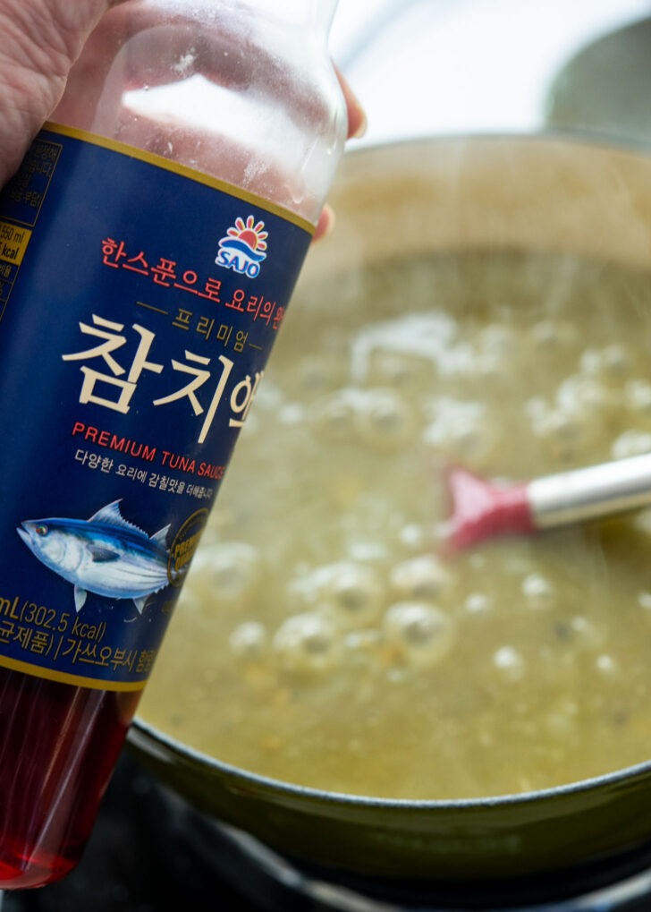 Seasoning jeonbokjuk with Korean tunna sauce in a pot