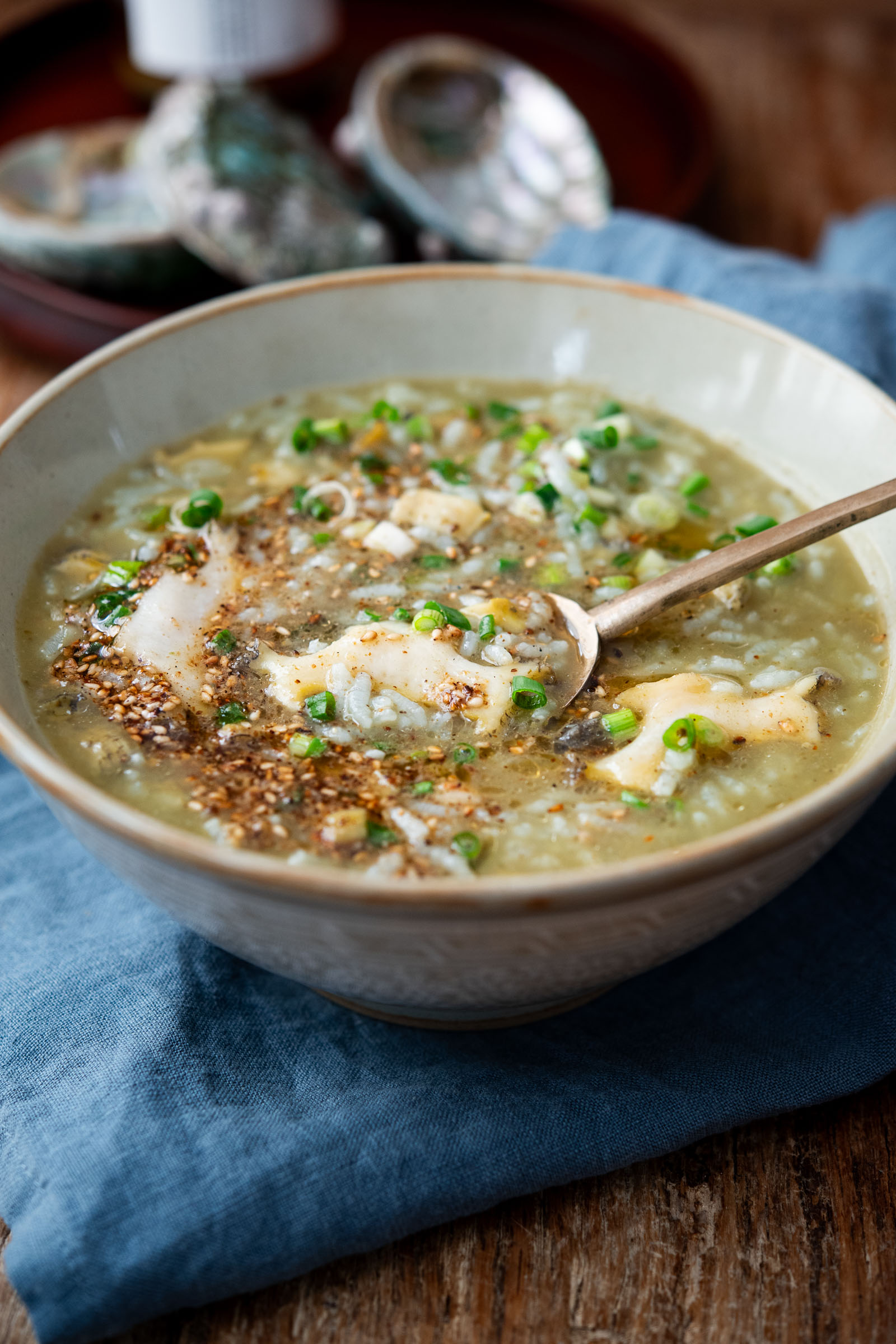 Bowl of Korean abalone porridge with green onion and sesame
