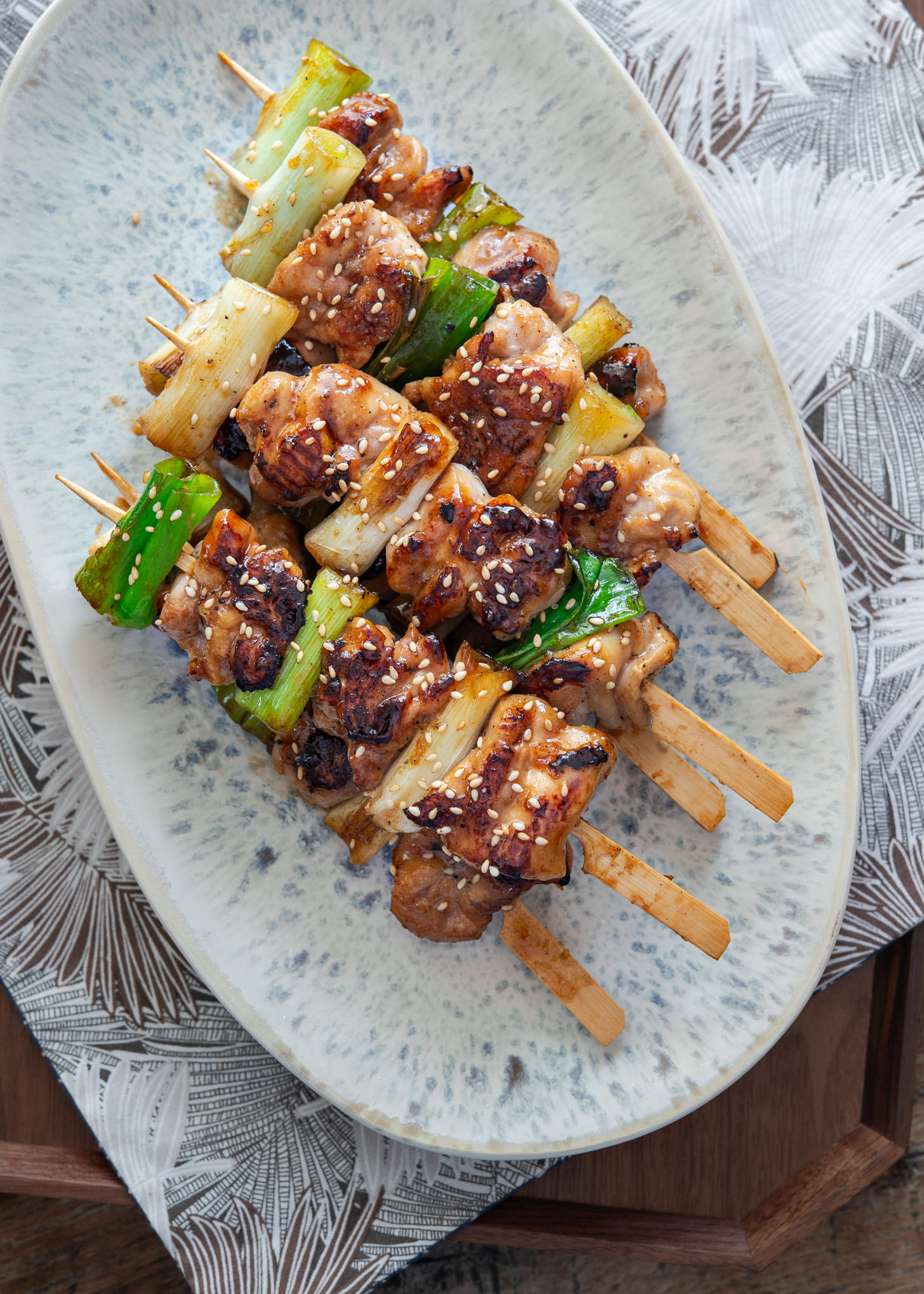 Korean chicken skewers (dakkochi) with soy-garlic glaze arranged on a serving plate.
