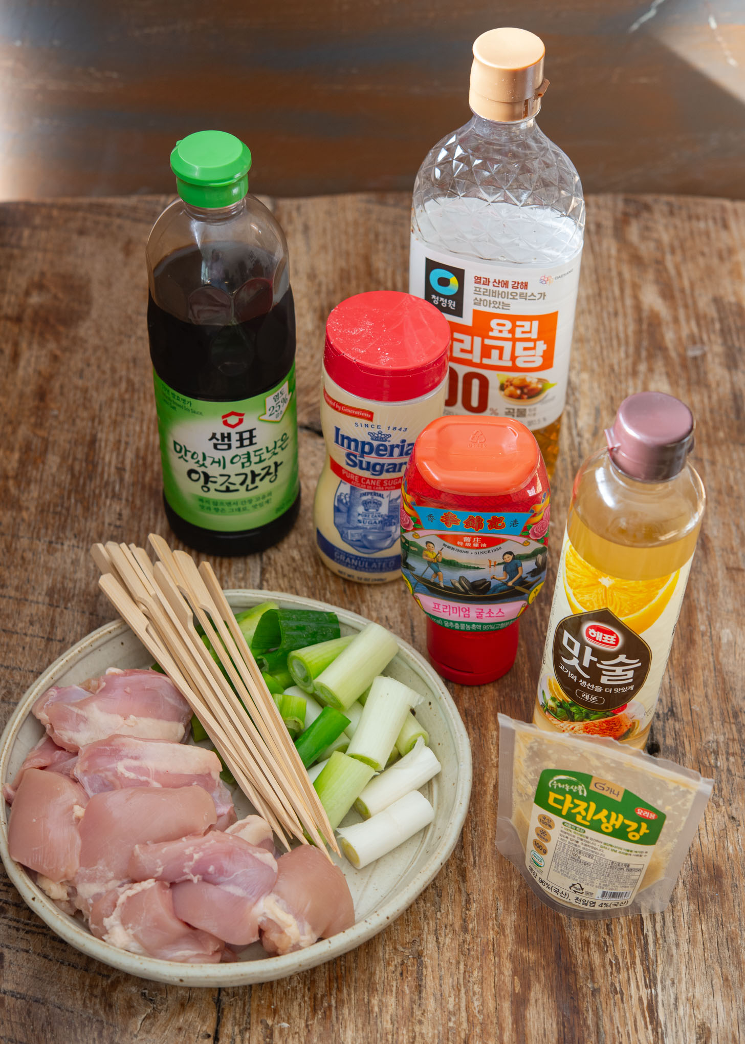 Chicken thighs, daepa, and soy-garlic glaze ingredients arranged for making dakkochi