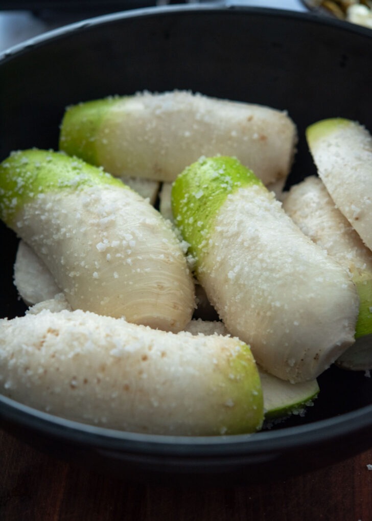 Korean radishes coated in sea salt and stacked together to brine
