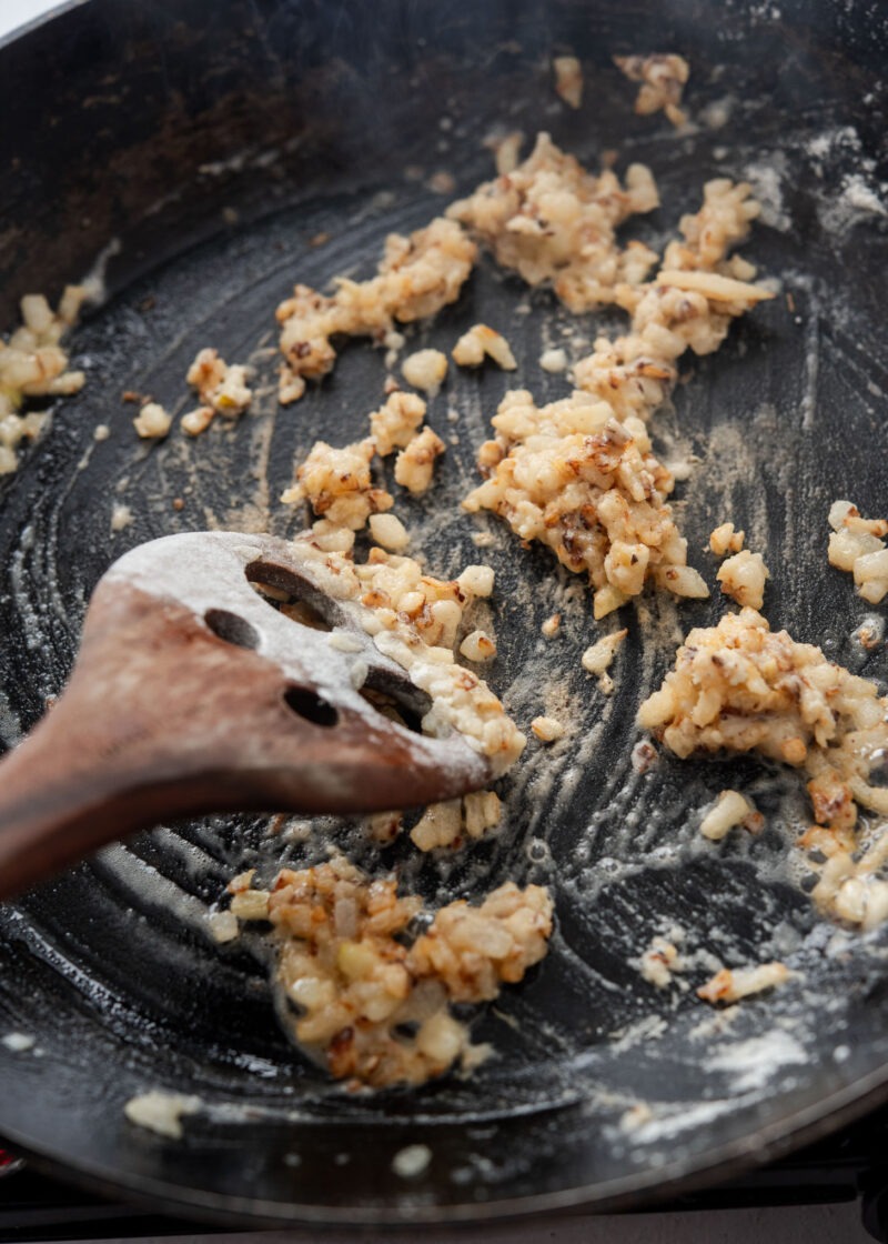 Stirring flour into browned onion to thicken Korean donkatsu sauce