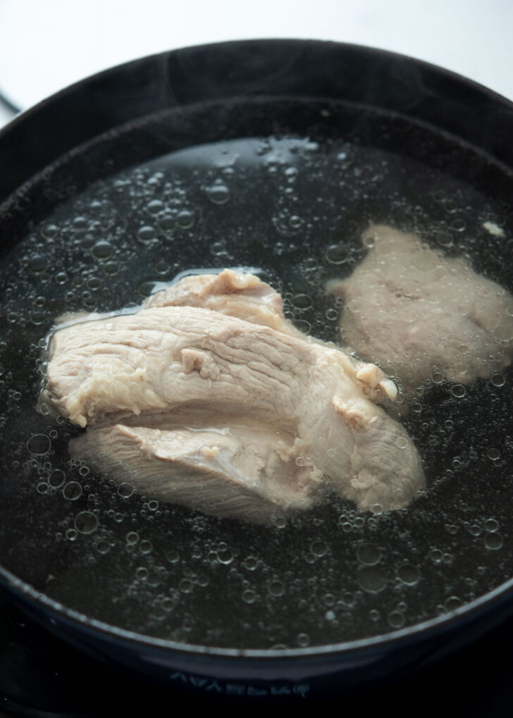 Pork shoulder simmering in a pot for dwaeji gukbap