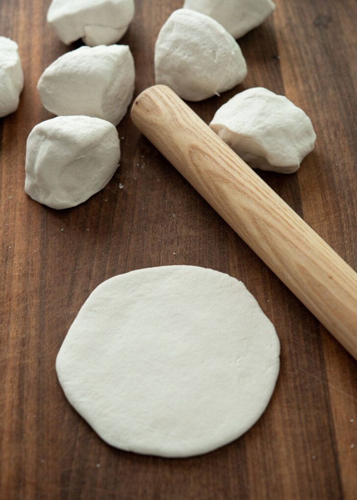Flattening hoppang dough with a rolling pin