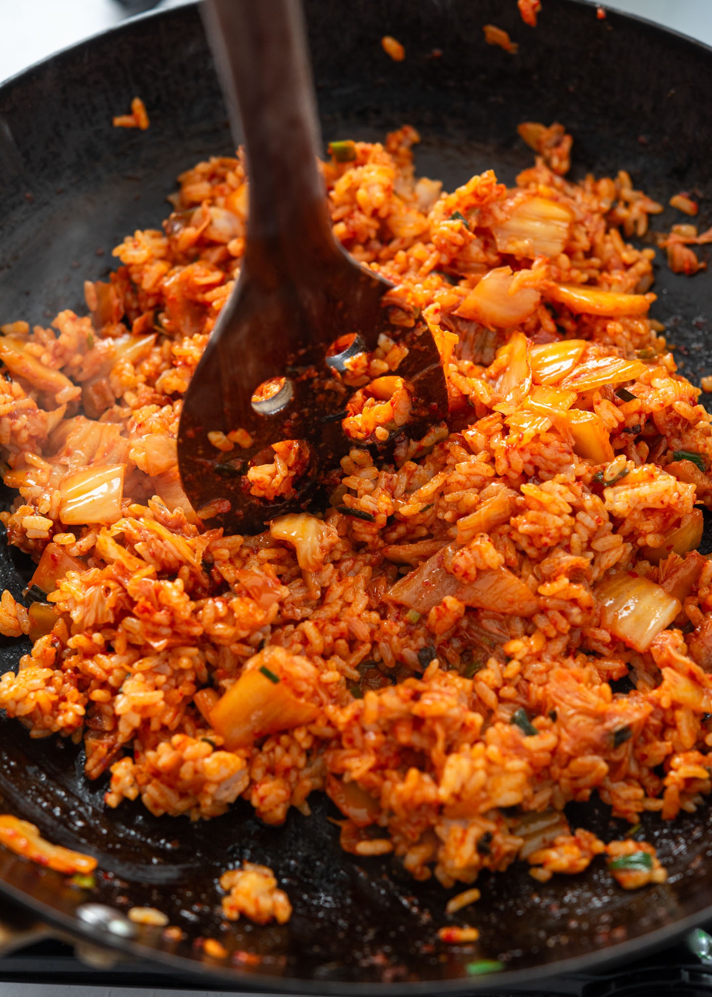 Using the edge of a spatula to break up rice clumps in the skillet