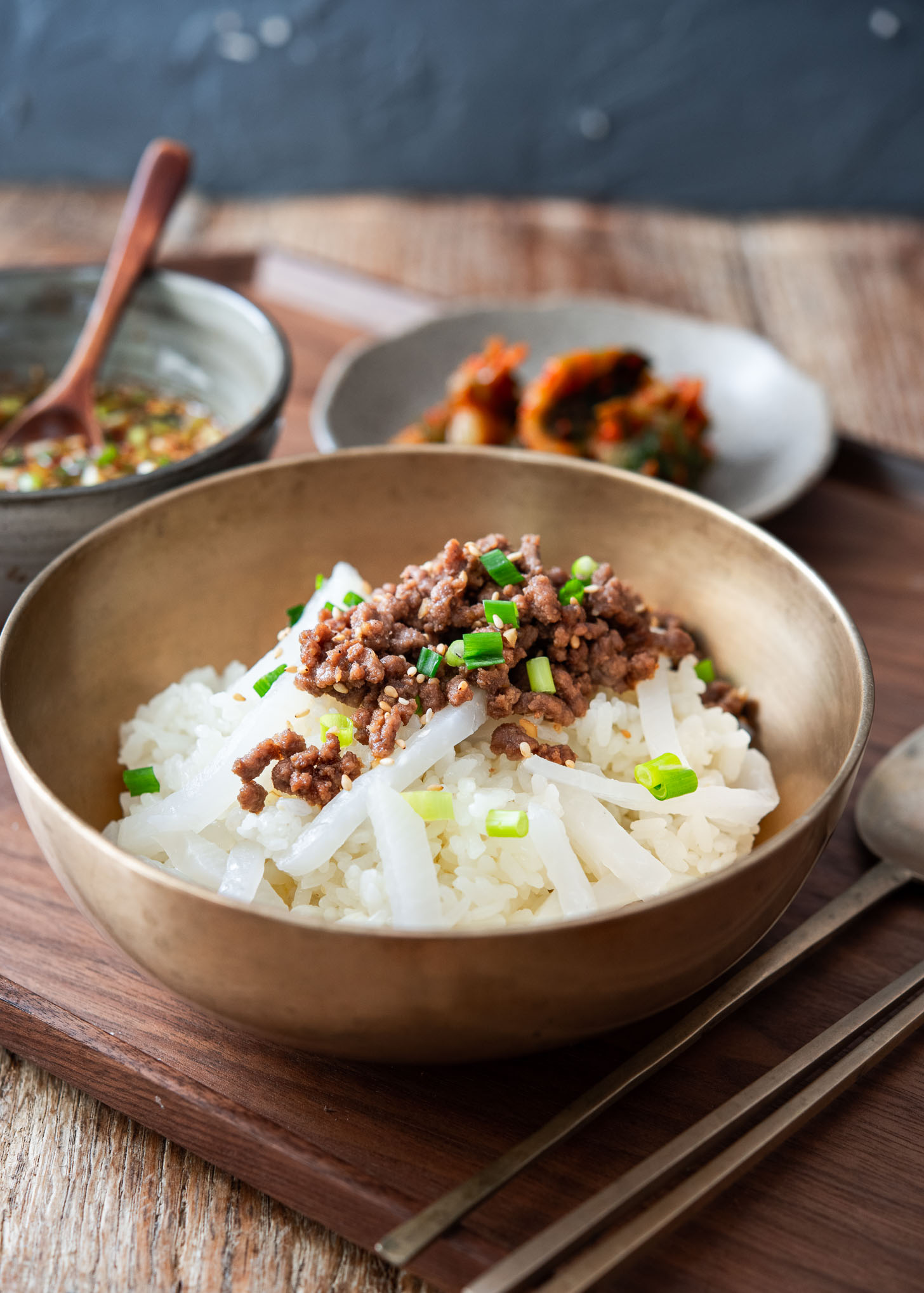 Tray with Korean radish rice bowls topped with ground beef bulgogi served with kimchi