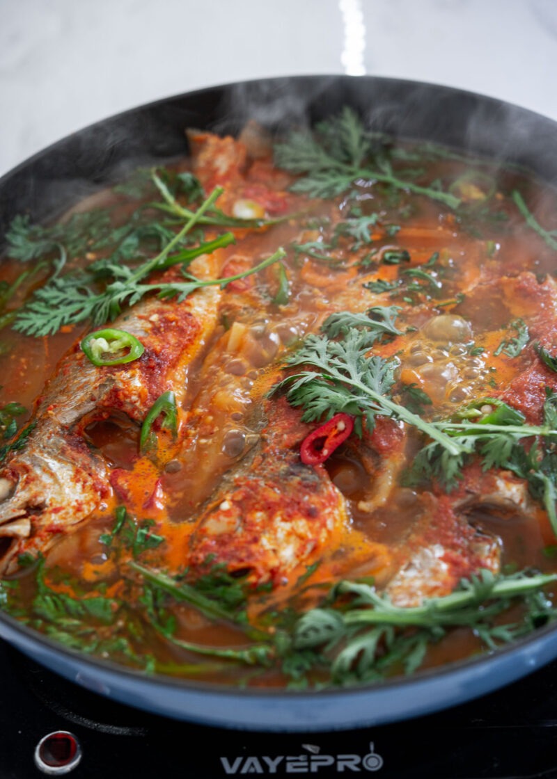 Maeuntang simmering with radish, greens, and red chili broth