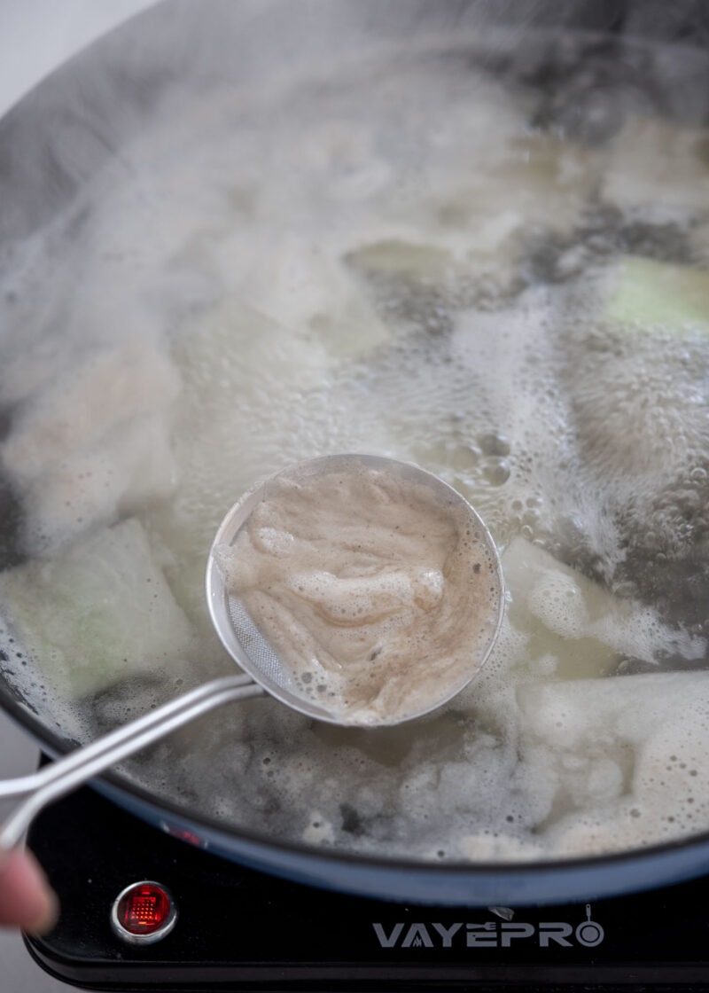 Skimming foam from broth to keep Korean maeuntang clean and clear