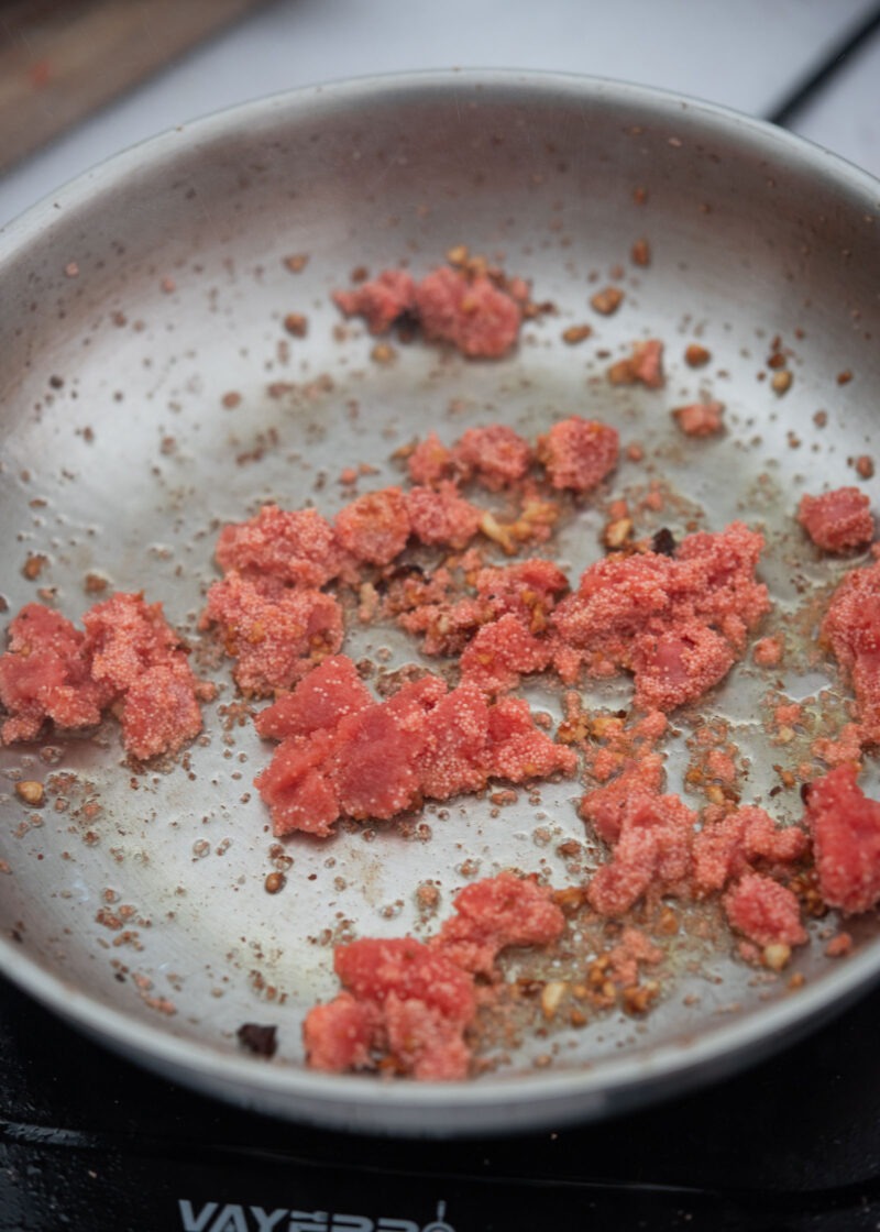 Mentaiko cooking in a pan with garlic and chili flakes
