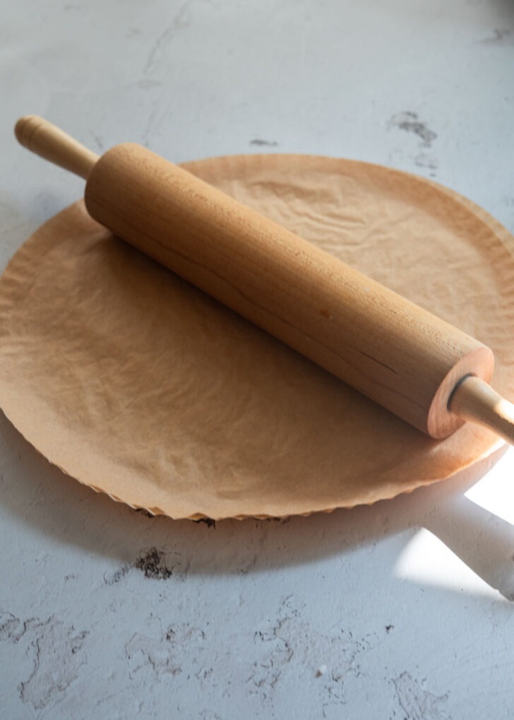 Flattening rice between parchment sheets with a rolling pin