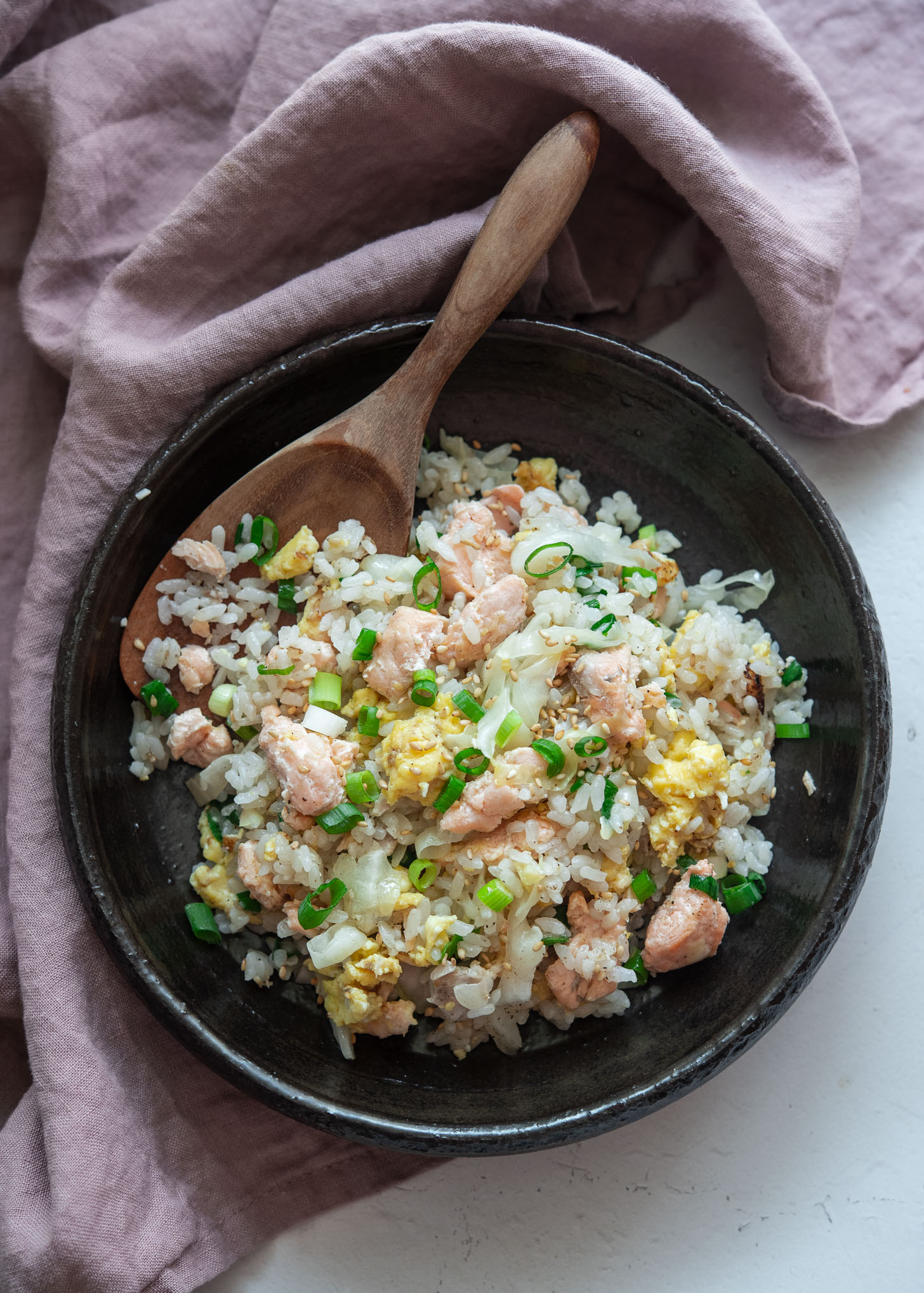 Salmon and egg fried rice served in a bowl with a spoon