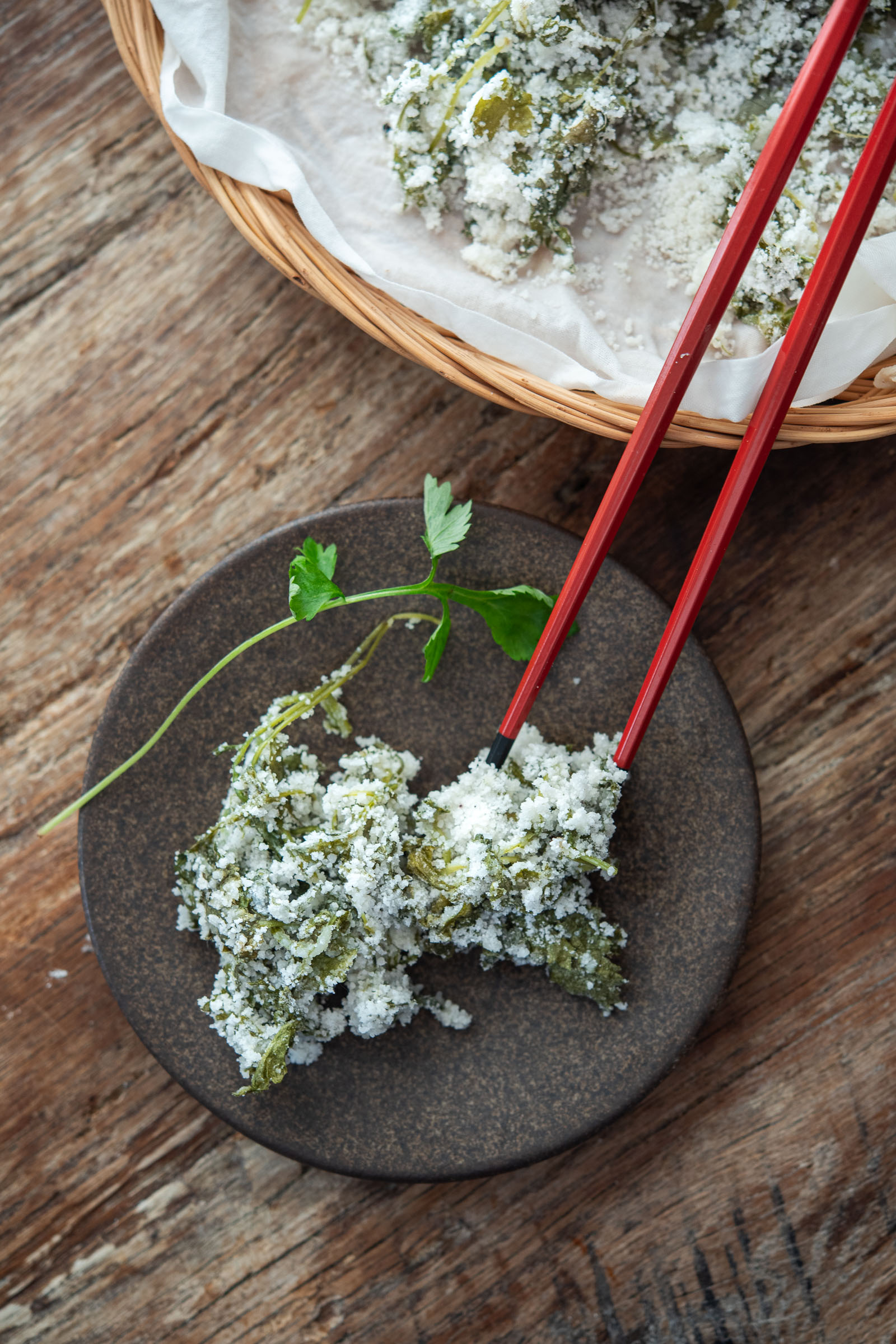 Piece of ssuk beomuri (Korean mugwort rice cake) on a small plate with red chopsticks