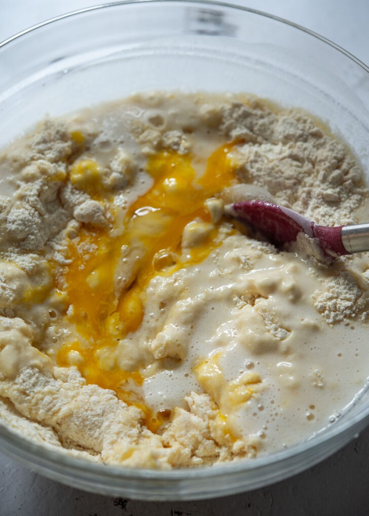 Adding makgeolli and eggs to sulppang batter ingredients
