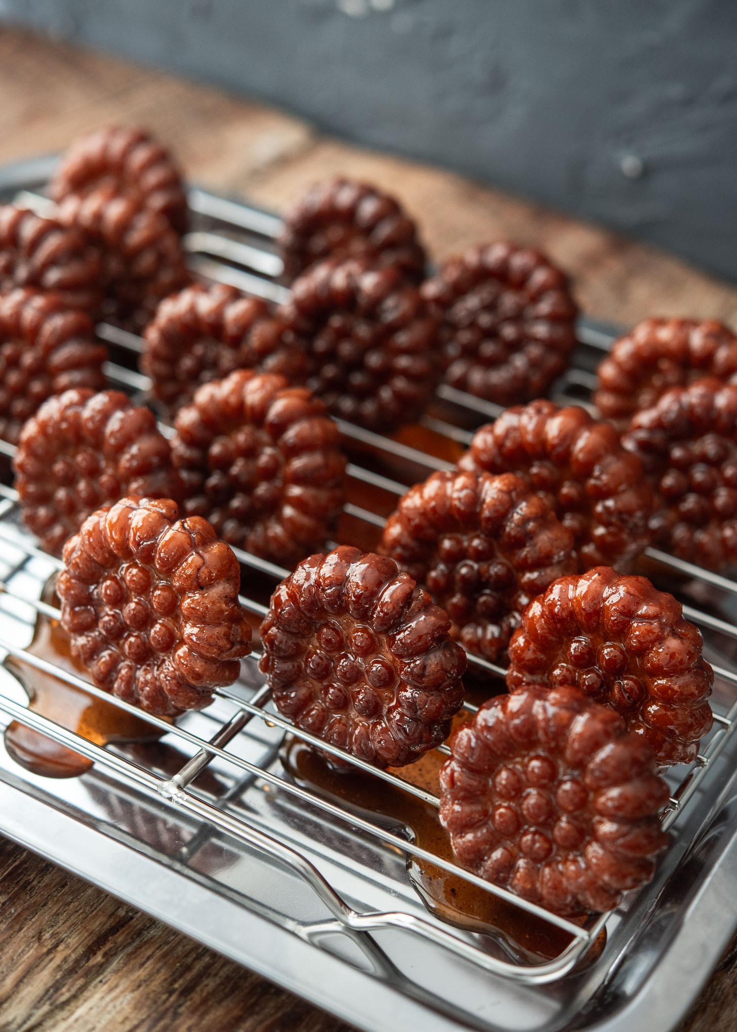 Resting the cookies on a rack to let excess syrup drip off