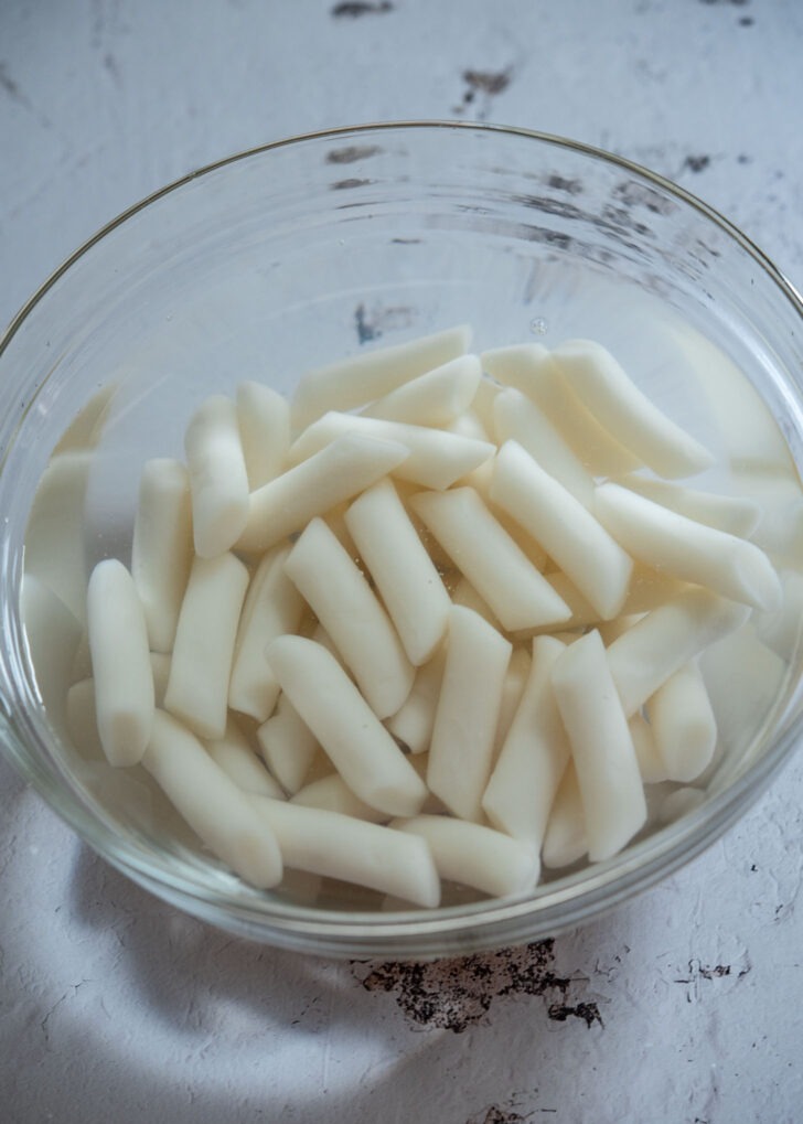 Rice cakes soaking in a bowl of water
