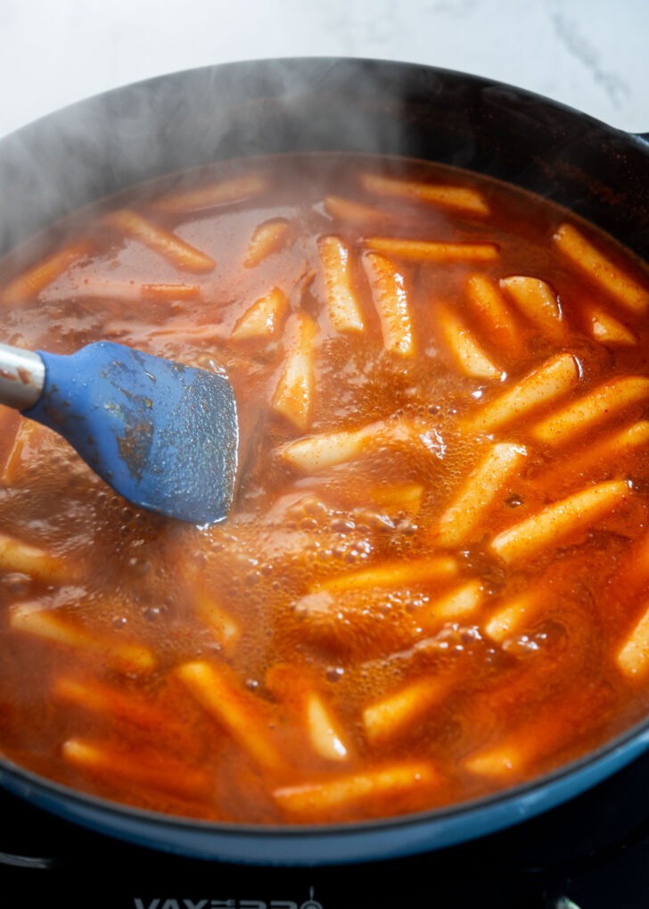 Rice cakes simmering in red tteokbokki sauce
