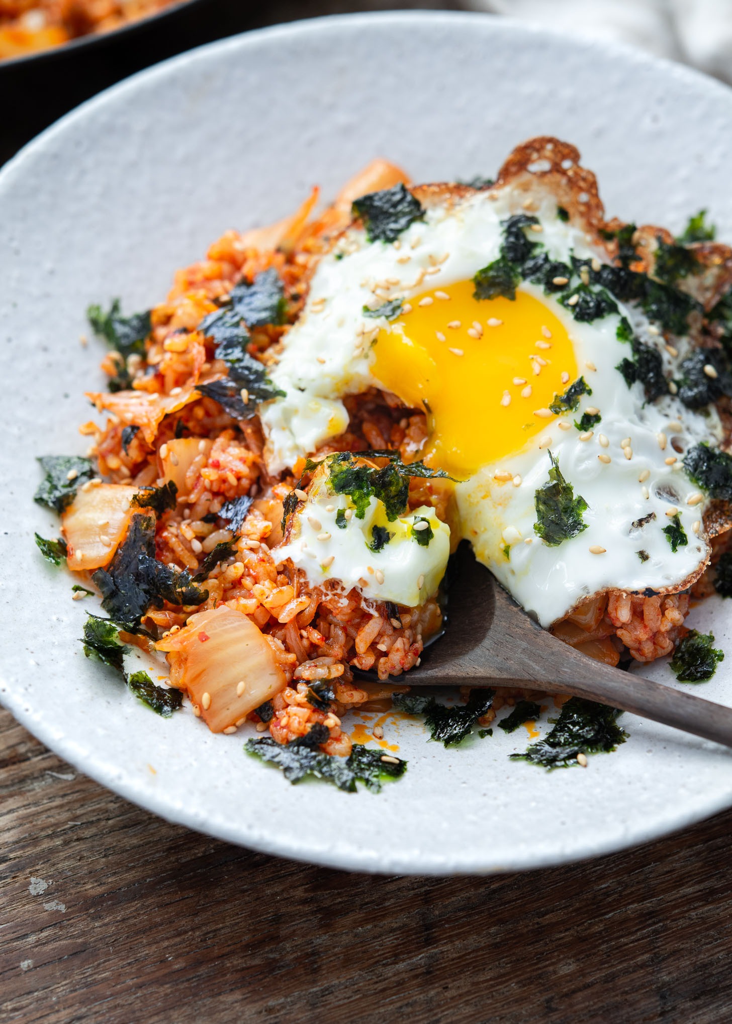 Spooning kimchi fried rice with a runny yolk breaking over the rice
