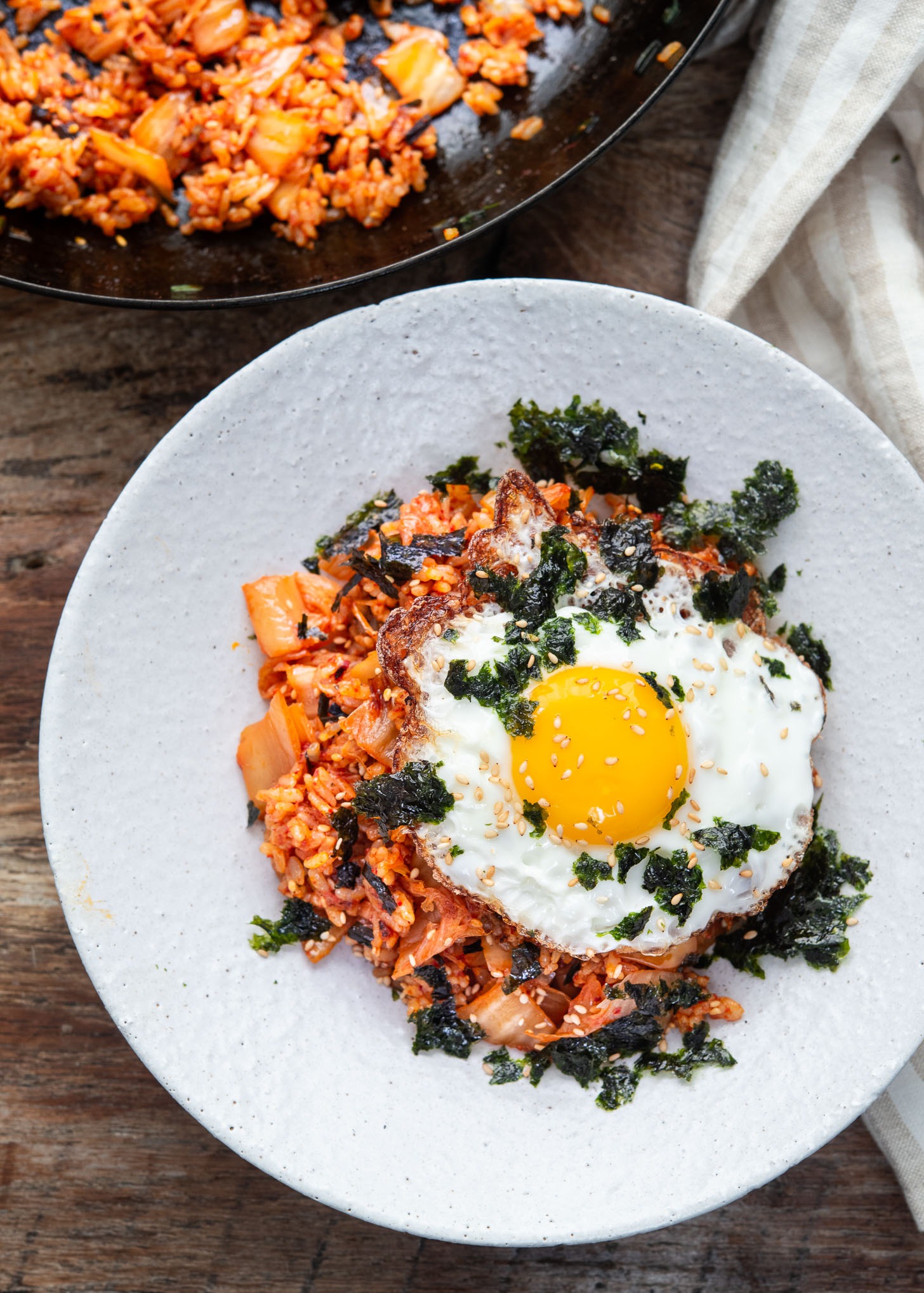 Overhead view of kimchi fried rice with fried egg and seaweed on top