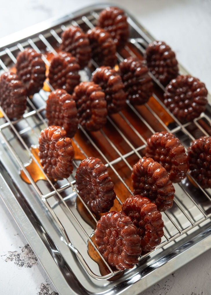 Draining excess syrup from the cookies on a rack