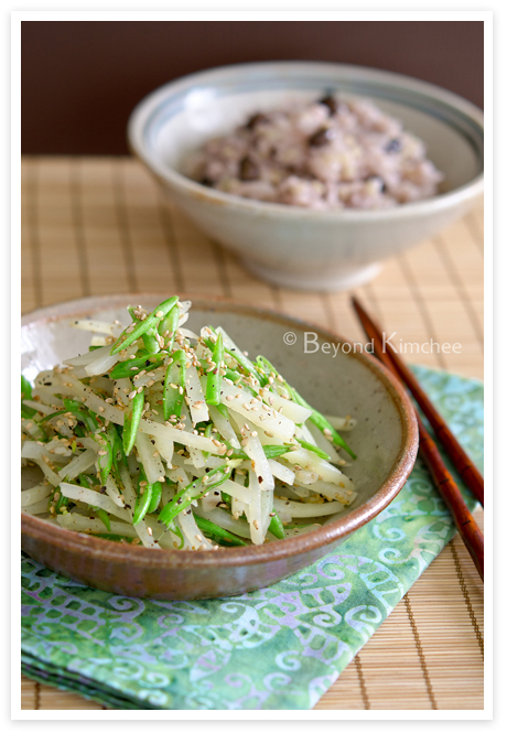 Shredded potato with green bean side dish in a stone plate is served with rice.