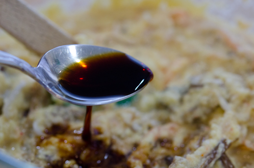 A spoonful of soy sauce is added to the bindaetteok batter mixture.